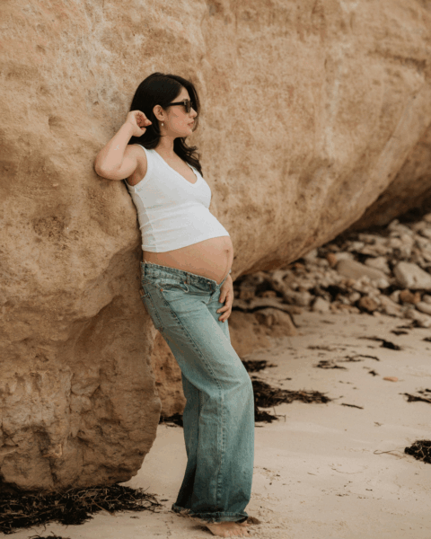 Persoon die zichtbaar zwanger lijkt en op het strand staat, als illustratie van het risico van het Zikavirus tijdens de zwangerschap.